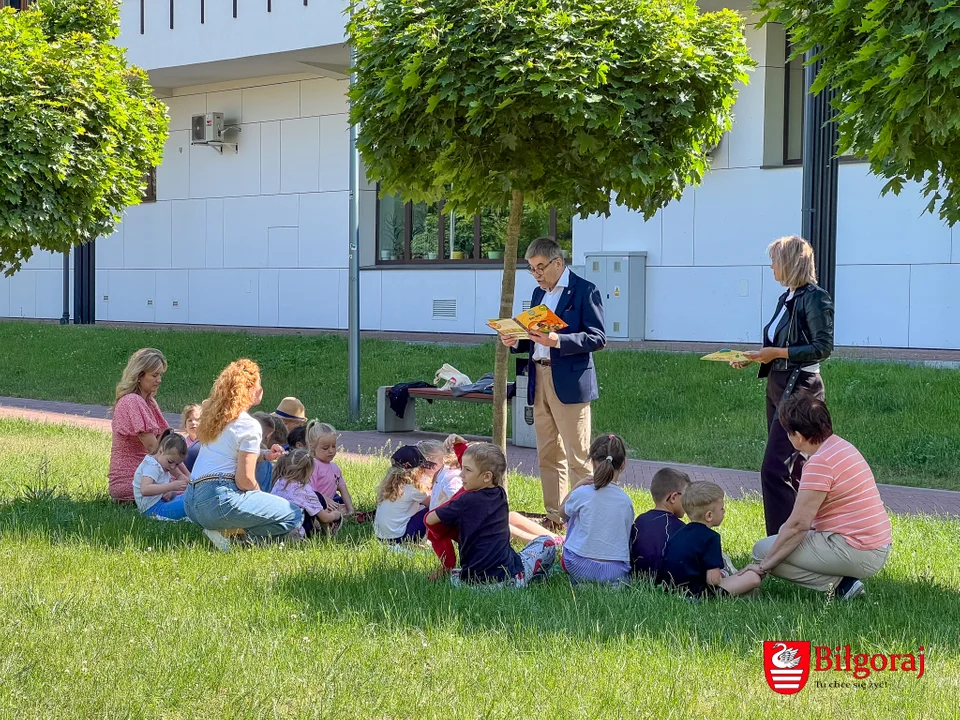 Czytanie na polanie. Dzieciom czyta dyrektor i sekretarz  (foto) - Zdjęcie główne